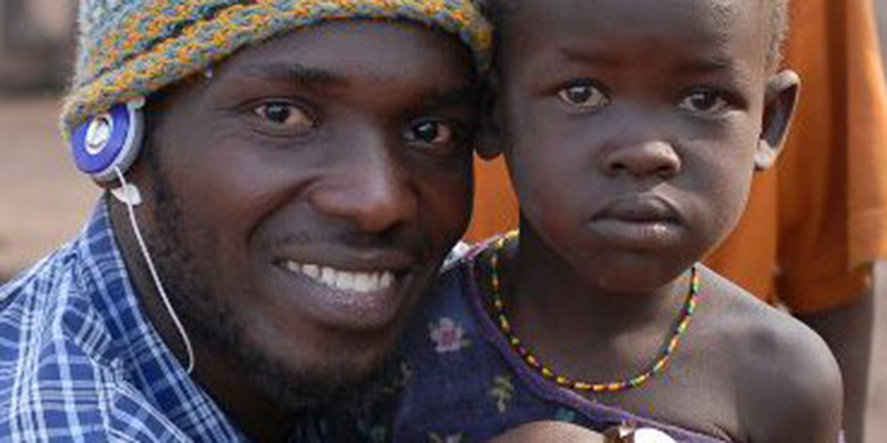 Film producer Onen with a child during his award winning documentary which he did in Karamoja 