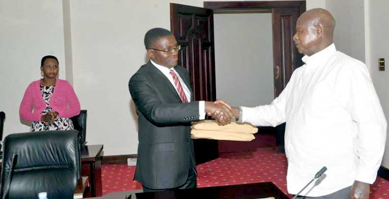 Katikkiro Mayiga getting the titles from President Yoweri Museveni in Entebbe