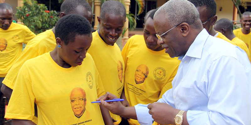 John Patrick Amama Mbabazi, who declared his intention to unseat president Museveni, auto-graphing T-Shirts worn by his supporters while at his home in Kololo recently. Pix from Mbabazi's Facebook page