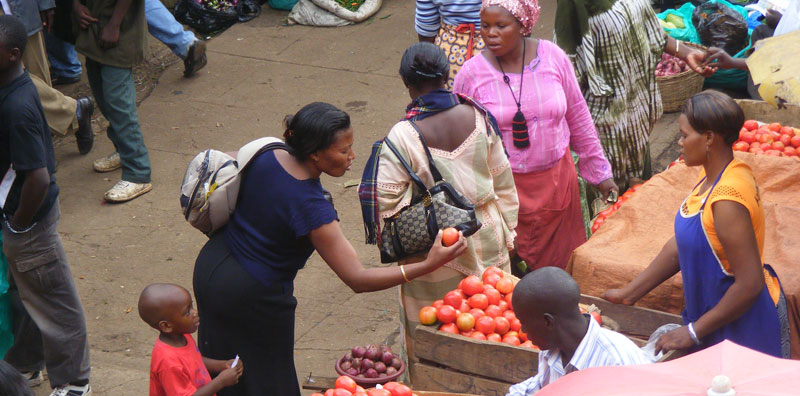 A customer buying tomatoes from the Market