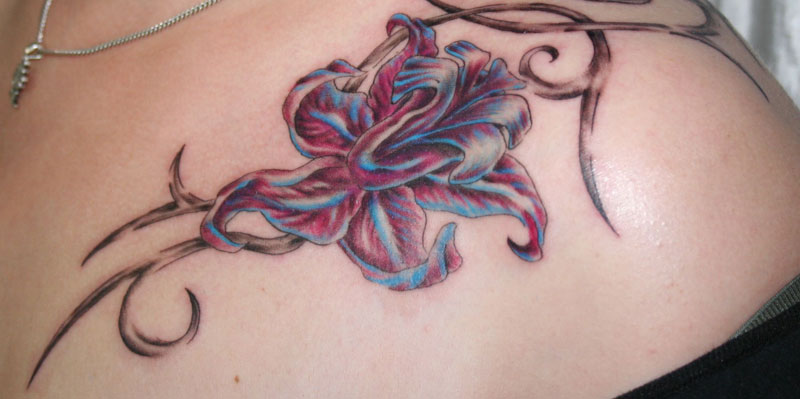 A lady spots a flower tatoo on her shoulder
