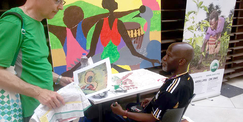 Nuwa Nnyanzi(right) showing an art piece to a client