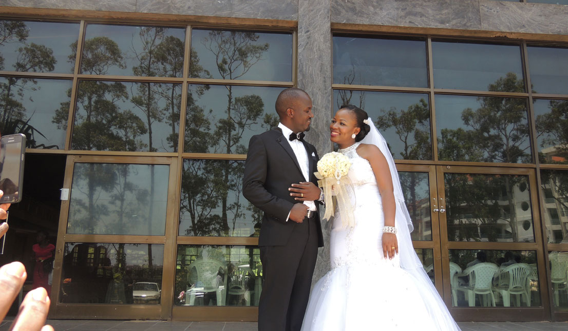 Groom Solomon and his bride Julie Bukirwa protocol manager pose for a photo