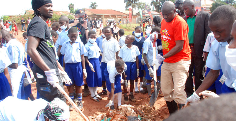 Bobi Wine with school children collecting garbage in Kamwokya