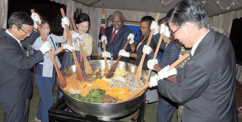 Ambassador Park is joined by guests to stir his country's traditional dish cooked with rice and vegetables. The dish was served to guests along with several other delicious dishes