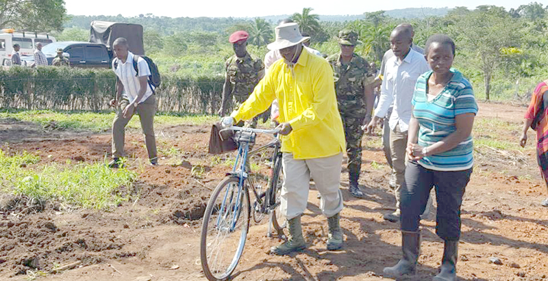 President Museveni carring a jerrycan of water on a bicycle