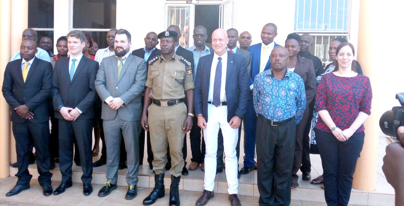Deputy Director of Human Resource Felix Ndyomugenyi (C), and German Liaison officer Rudiger Stransky (IN (tie) pose for a photo with some of the partcipants