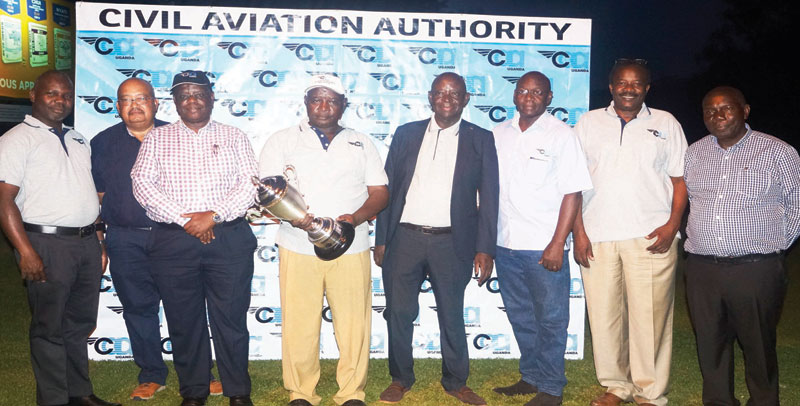 CAA Managing director Dr. David Kakuba (Center) after handing over the Uganda Seniors Golf Open winner’s trophy to Mr. Stephen Katwiremu at the Kampala Golf Club recently. Extreme right is Mr. Mark Ntege the vice chairman Seniors Golfing Society, Eng. John Kagoro Director Airports and Aviation Security CAA and Mr. Richard Ruhesi, Director Air Navigation Services. Third left is the Director Human Resource and Administration Mr. Fred Bamwesigye. Mr Patrick Billy the Treasurer Uganda Seniors Golfing Society (Second left) and Mr. Vianny Luggya manager Public Affairs CAA