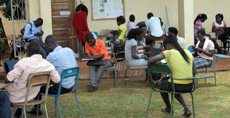 Gulu university students sitting outside one of the lecture rooms as their teachers stayed away