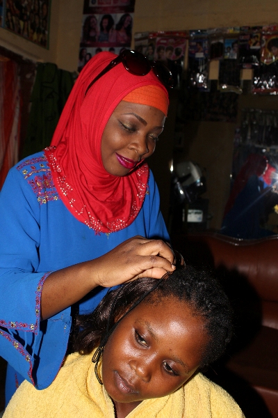 Aisha Bahati plaiting the hair of one of her customers