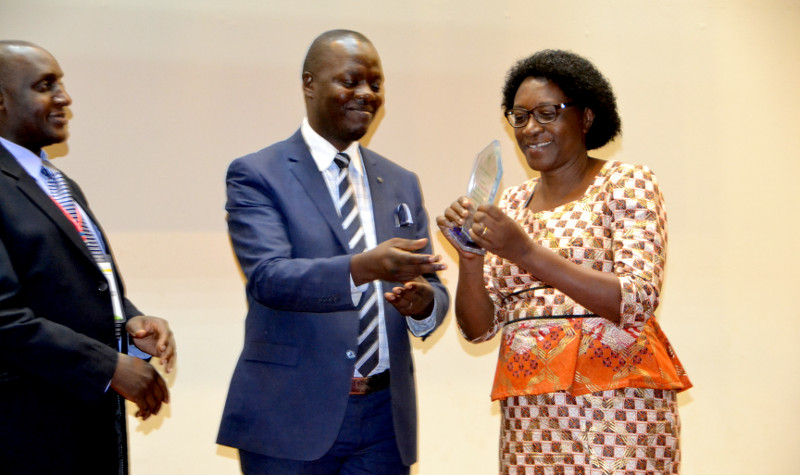 Prof. Margaret Mangeni Najjingo (rigt) receives an award from Buvuma County MP Robert Migadde Ndugwa during a Dinner ceremony held Wednesday March 14, 2018 at Hotel Africana in Kampala. The awards were co-organised by Uganda Forum for Agricultural Advisory Services (whose chairperson, Henry Nsereko is pictured looking on, and its Africa-wide umbrella body AFAAS.