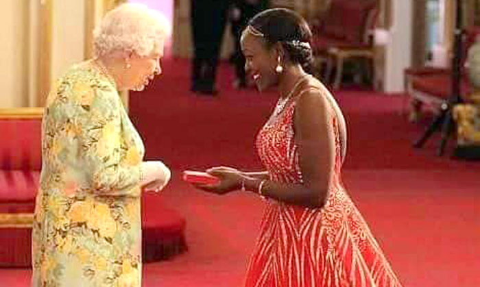Elizabeth Kasujja receives her award from HM Queen Elizabeth II 