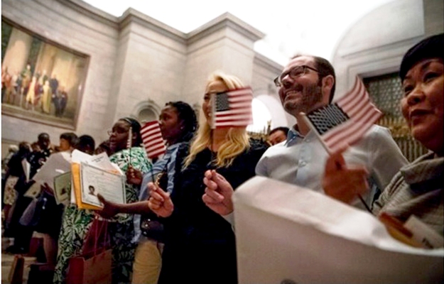 Thirty-one new citizens from 25 nations are sworn in at a naturalization ceremony as part of a celebration of the Constitution at the National Archives in Washington.