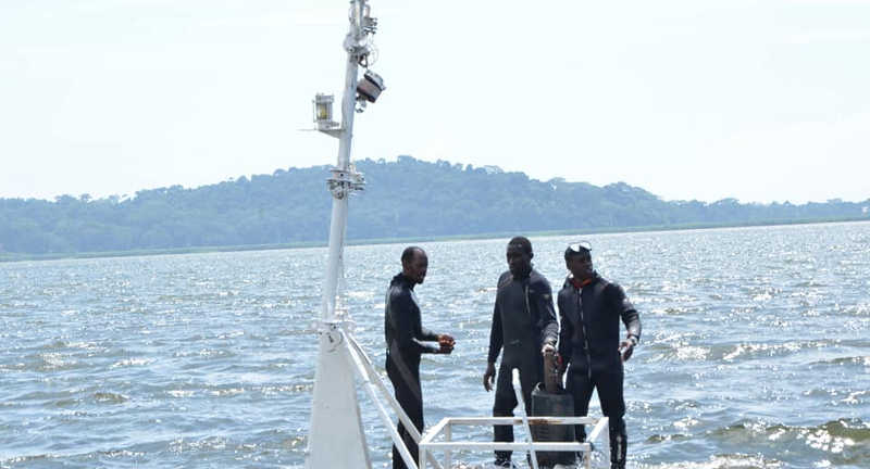 Police divers stand on the boat  that capsized on Saturday killing more than 33 people