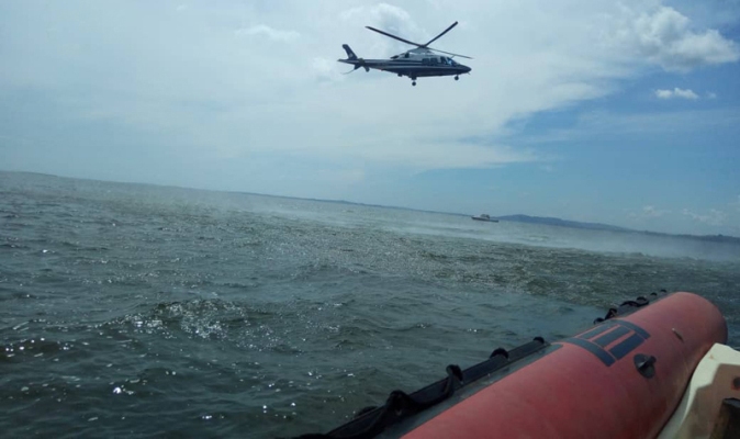 A Police helicopter hoovers over Lake Victoria where the supposed cruise boat sunk killing revelers