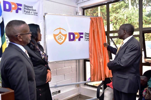 Minister Matia Kasaija unveiling the DPF logo as Julia Clare Olima Oyet CEO looks on