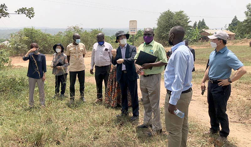 Dr-Godfrey-Seruwu–from-MuZARDI-showing-the-Korean-experts-and-officials-from-Luwero-District-Local-Government-the-potential-site-for-the-seed-dissemination-farm-in-Bbowa-village-Luwero-District