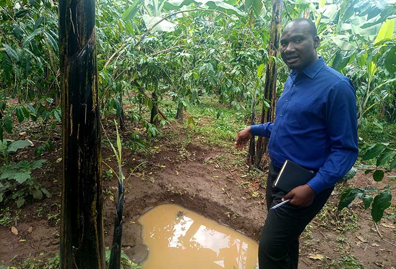 Mr. Sam Wakibi, the Community Development Officer of Bukalasi Sub County in Bududa district shows how they dig pits that trap water and soil to prevent erosion, but also help in groundwater recharge.