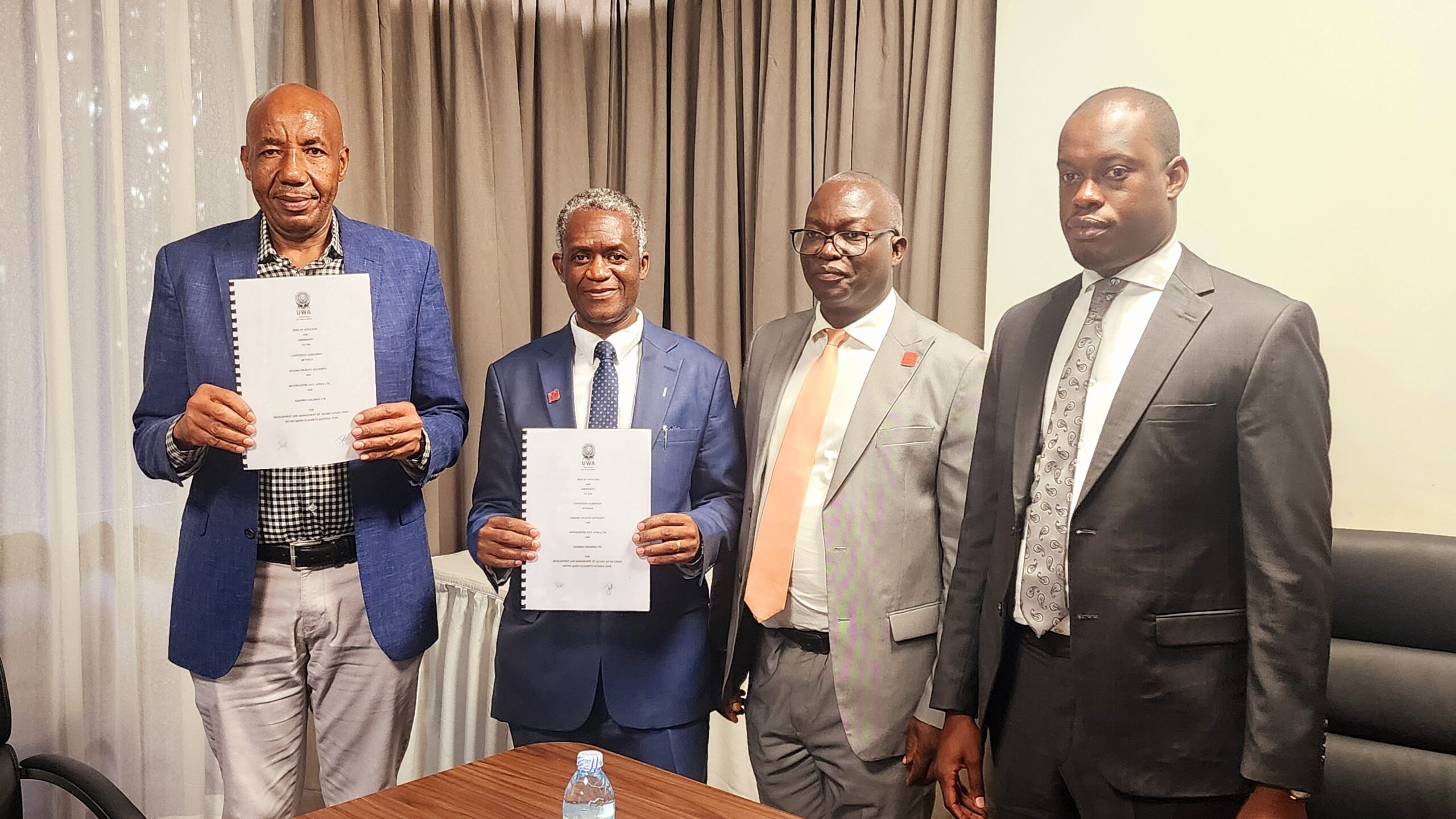 Mr. Epic Kagoro of Kagobed Holdings Ltd & Prof. James Kalema showing copies of the concession agreement. Right is Minister Martin Mugarra