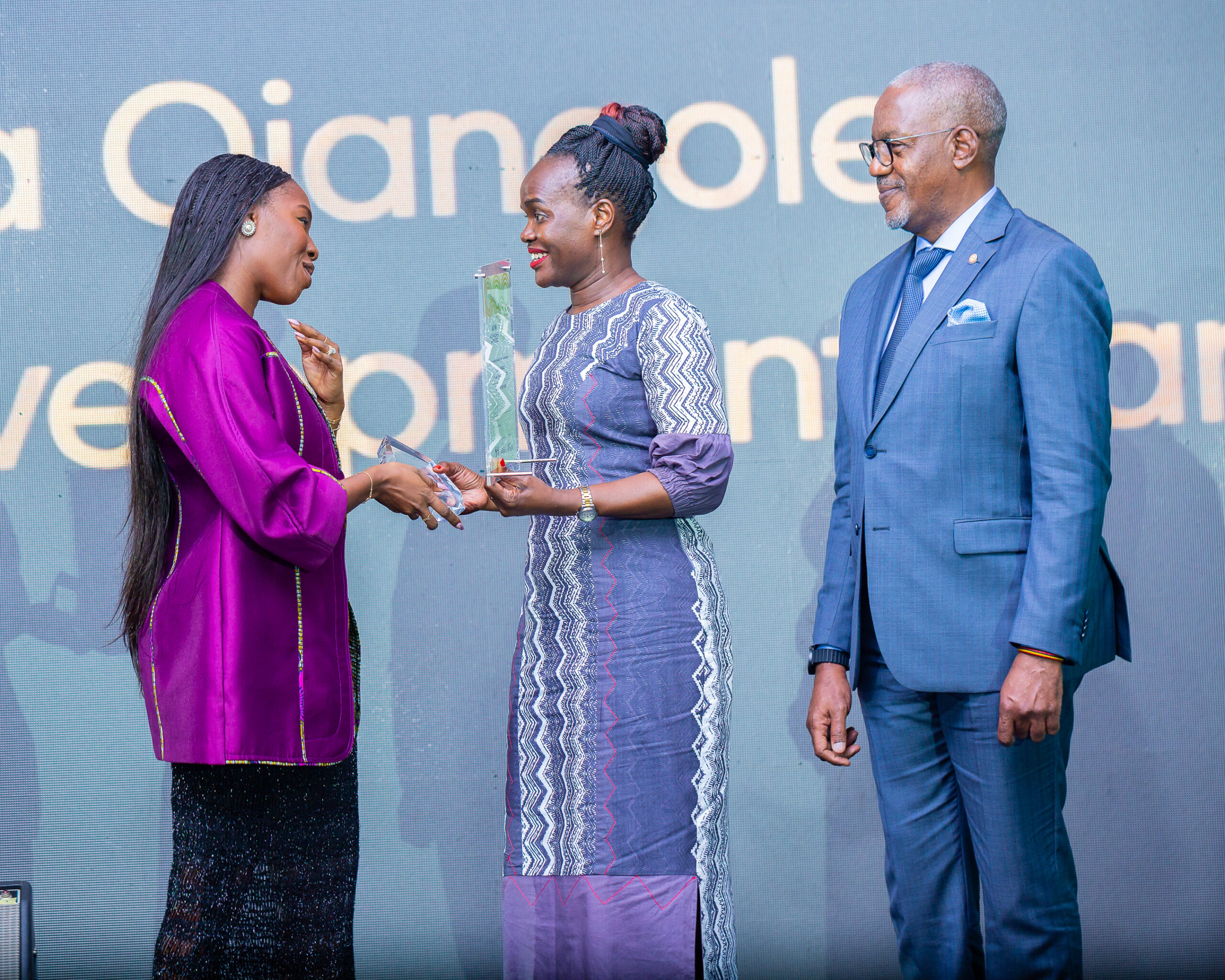 Dr.-Ojangole-receives-the-Award-from-Ivorian-sprinter-and-silver-medallist-Murielle-Ahoure-Demps.-Looking-on-is-UDB-Board-Chair-Geoffrey-Kihuguru-R-scaled